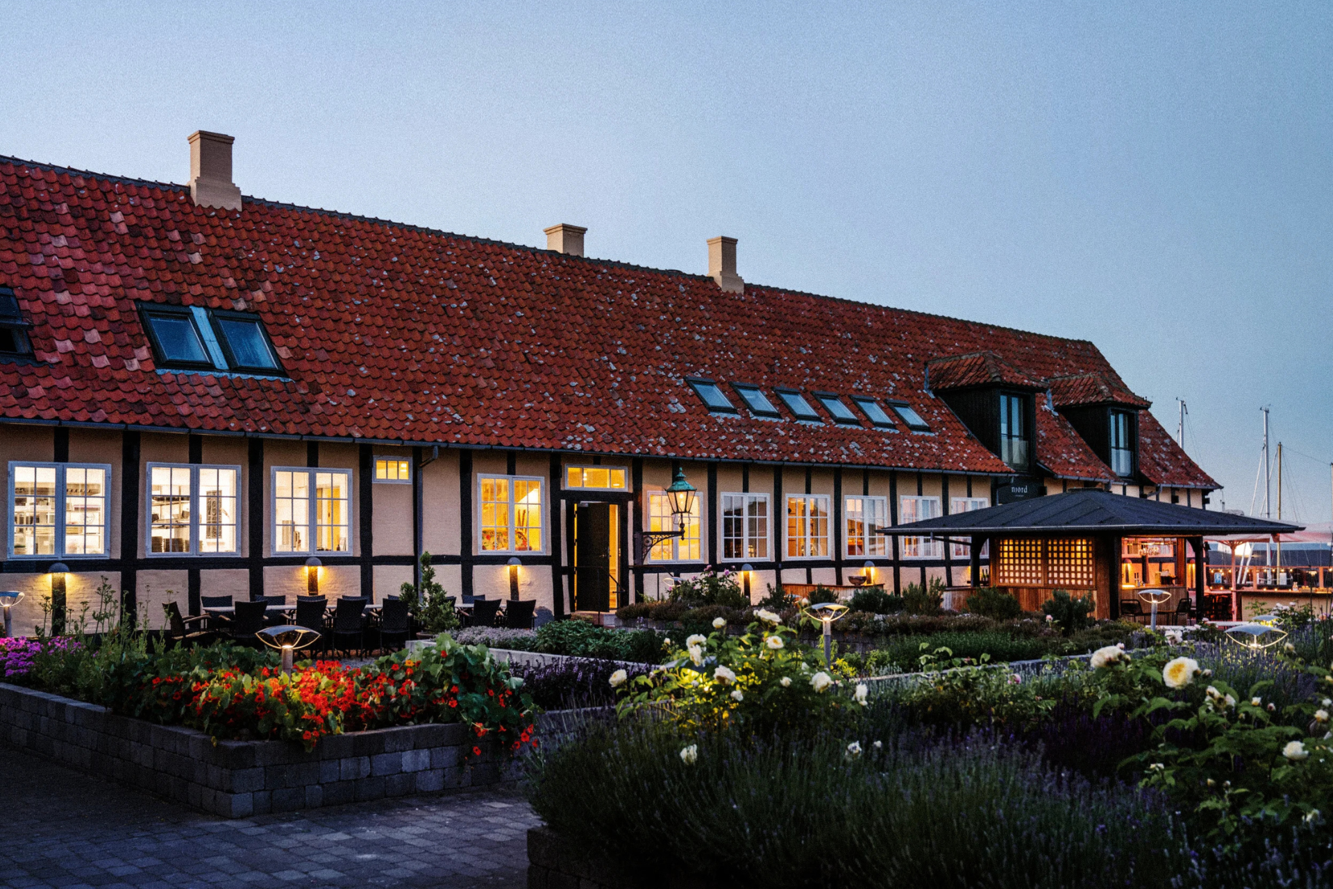 Siemens Gaard i aftenskumringen med udsigt over Svaneke Havn. Foto: PR
